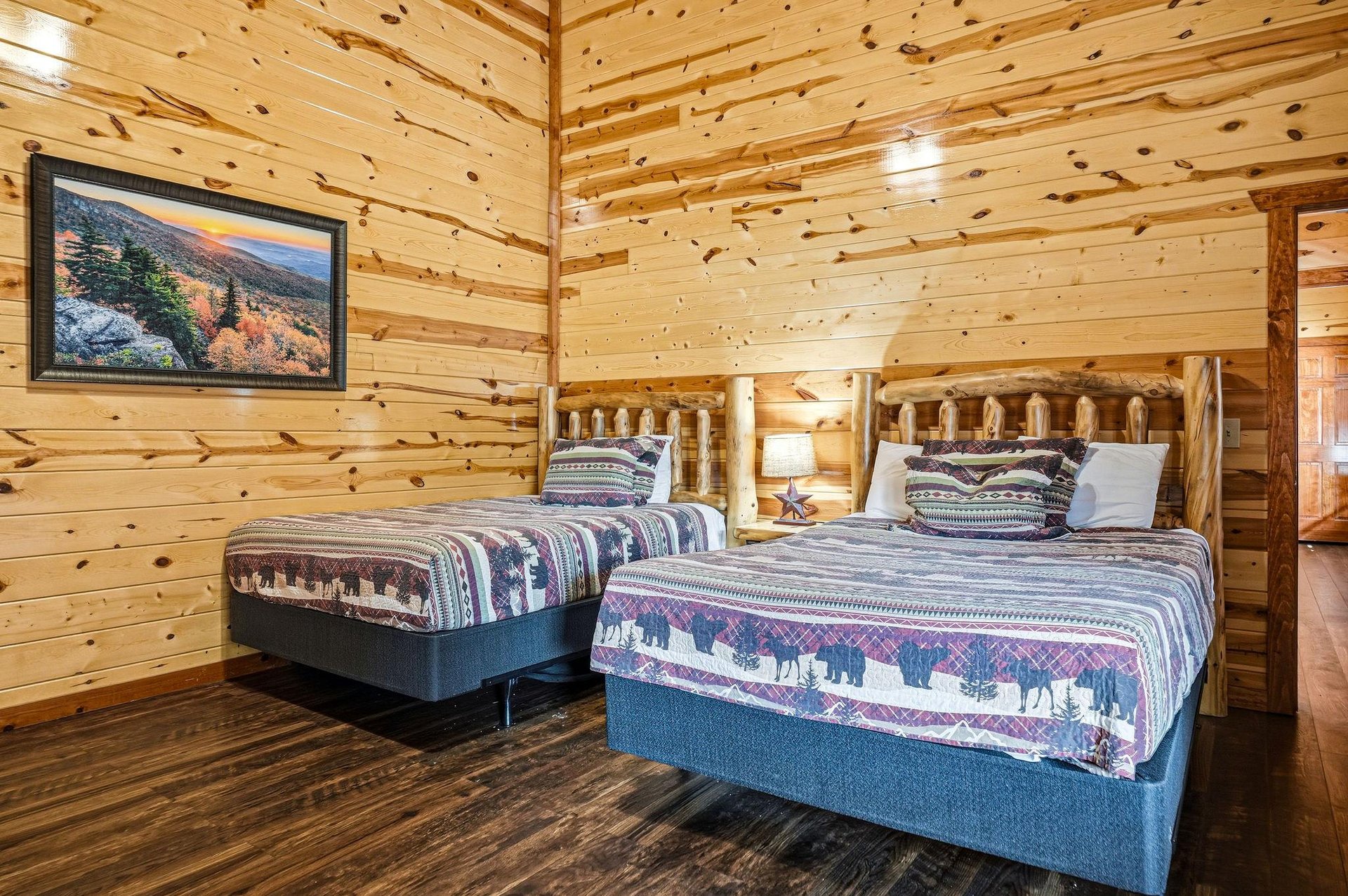 Cozy up in your rustic log bedroom featuring two comfortable beds with charming wildlifethemed linens and warm wood walls that create the perfect mountain retreat atmosphere.