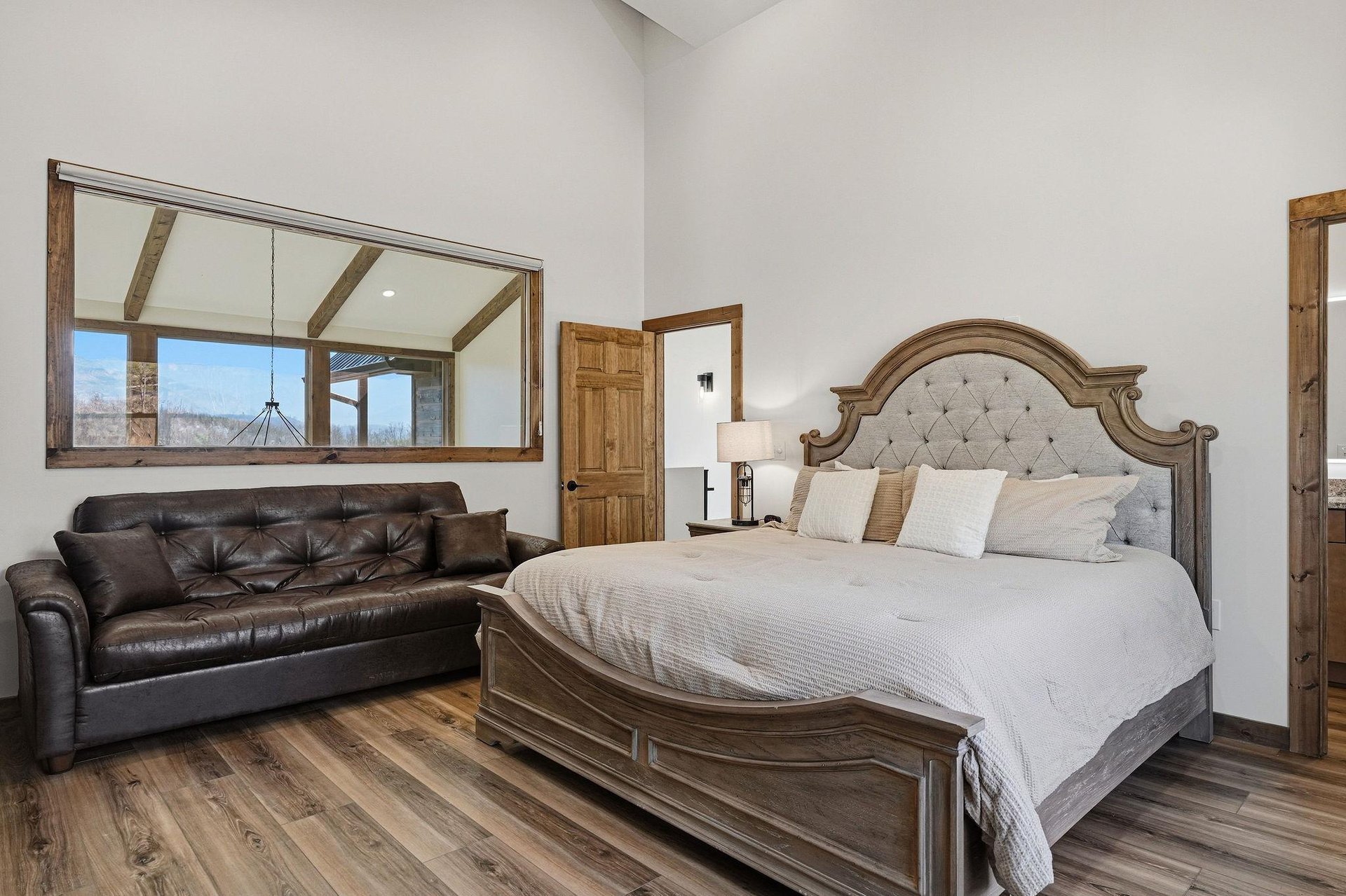 Sink into luxury with this elegant bedroom featuring a plush king bed and cozy leather seating area for your perfect retreat.