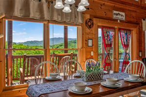 Gather around this inviting dining table and soak in breathtaking mountain views through expansive windows—your meals here come with a side of natural beauty and peaceful serenity.