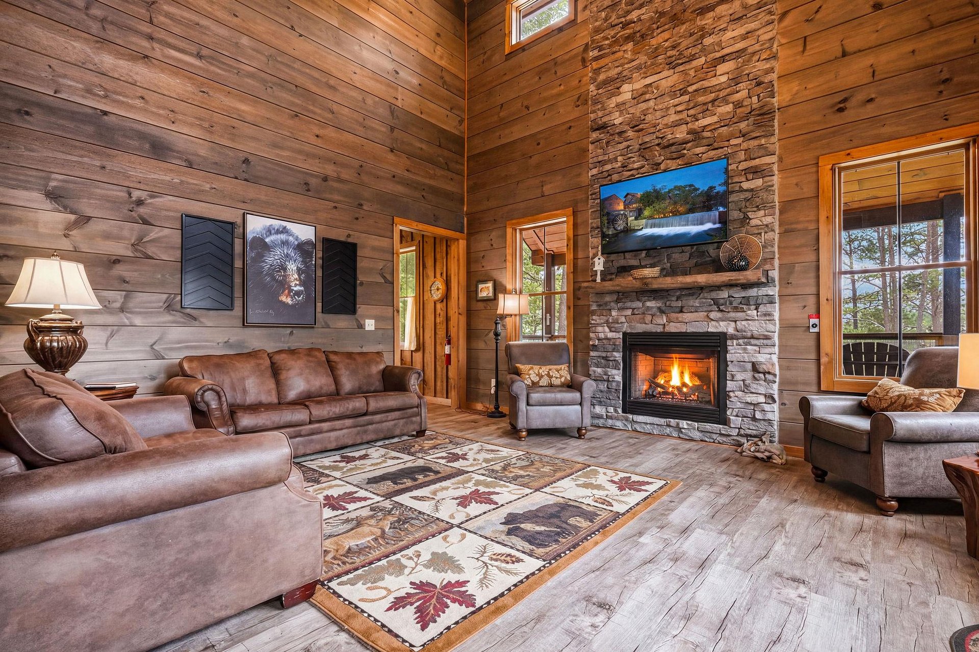 Curl up in plush leather seating beside the glowing stone fireplace, where vaulted woodbeam ceilings and forest views create your perfect mountain retreat.