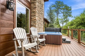 Step onto your private deck and sink into the hot tub as you gaze over lush treelined views. Two charming rocking chairs invite you to unwind and soak in the peaceful surroundings.