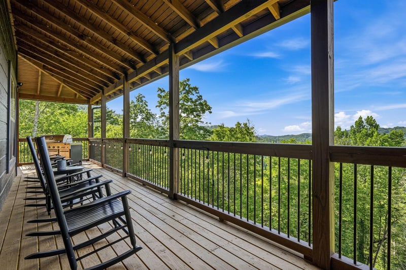 A covered deck with classic rocking chairs frames sweeping mountain and forest views—your peaceful spot to unwind and breathe in the scenery.