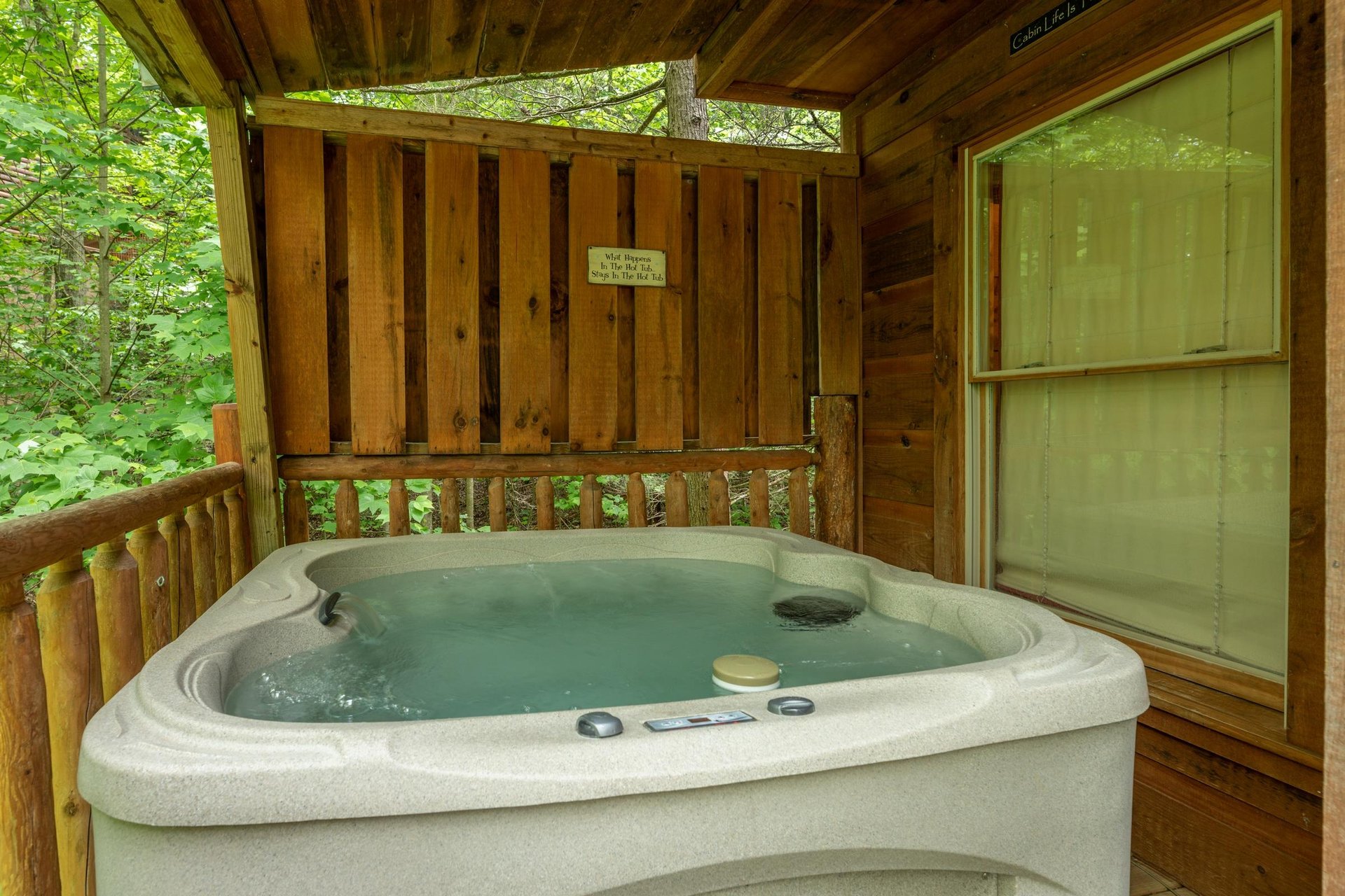 Hot tub and privacy fence on the deck at Logans Smoky Den, a 2 bedroom cabin rental located in Pigeon Forge