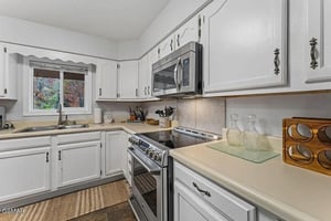 Your fully equipped kitchen invites culinary adventures with modern appliances, ample storage, and warm natural light streaming through garden views.