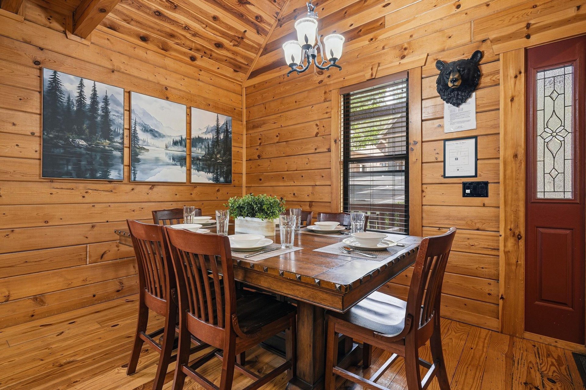 Gather around this rustic dining table where warm wood surrounds you and mountain artwork sets the perfect cabin atmosphere for your memorable meals together.