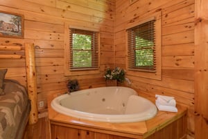 Heartshaped jacuzzi in a bedroom at Dreams Do Come True, a 1bedroom cabin rental located in Pigeon Forge