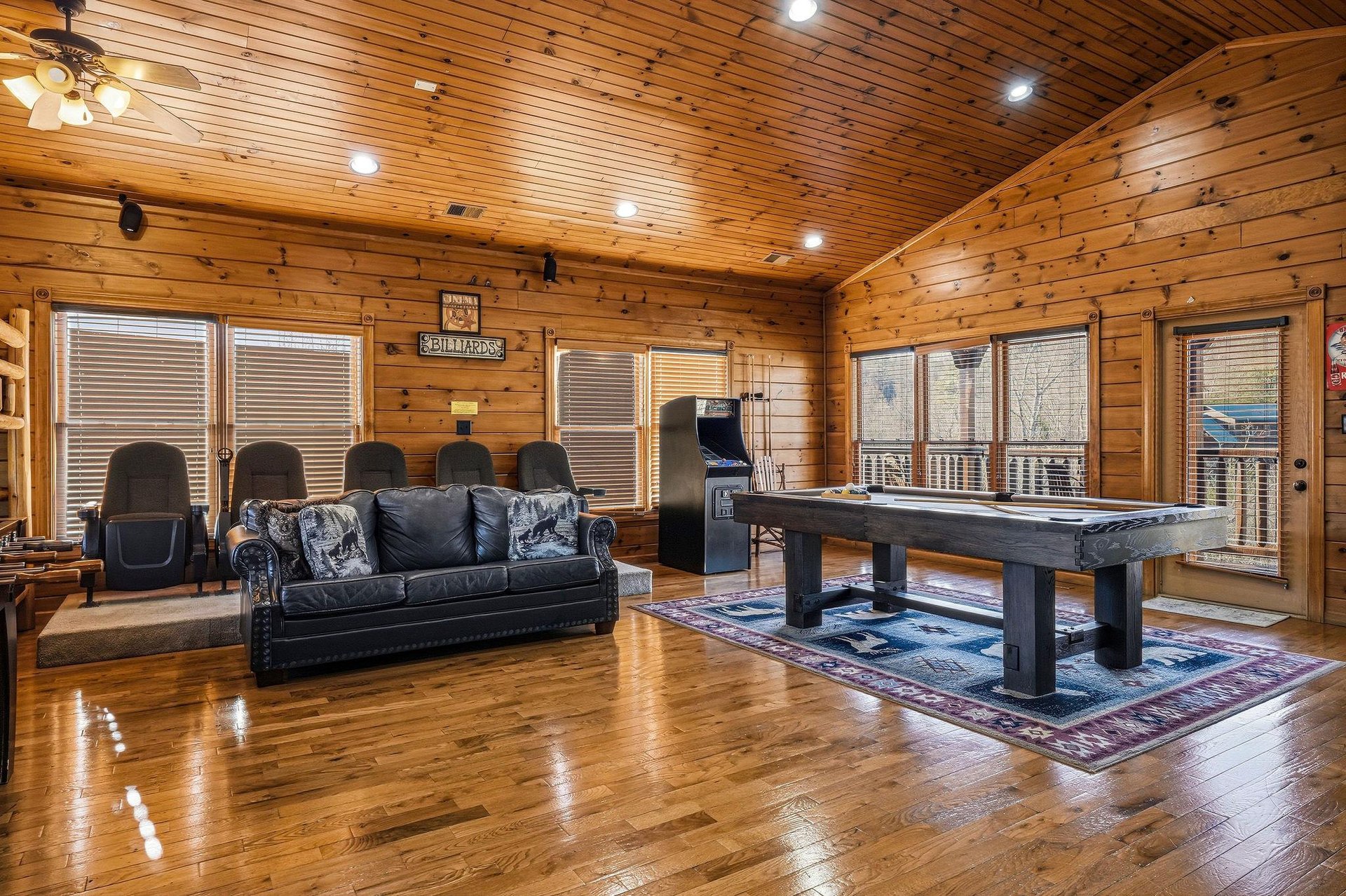 Step into your spacious game room where warm wood surrounds you, inviting friendly competition at the pool table or relaxed evenings on the plush leather sofa.