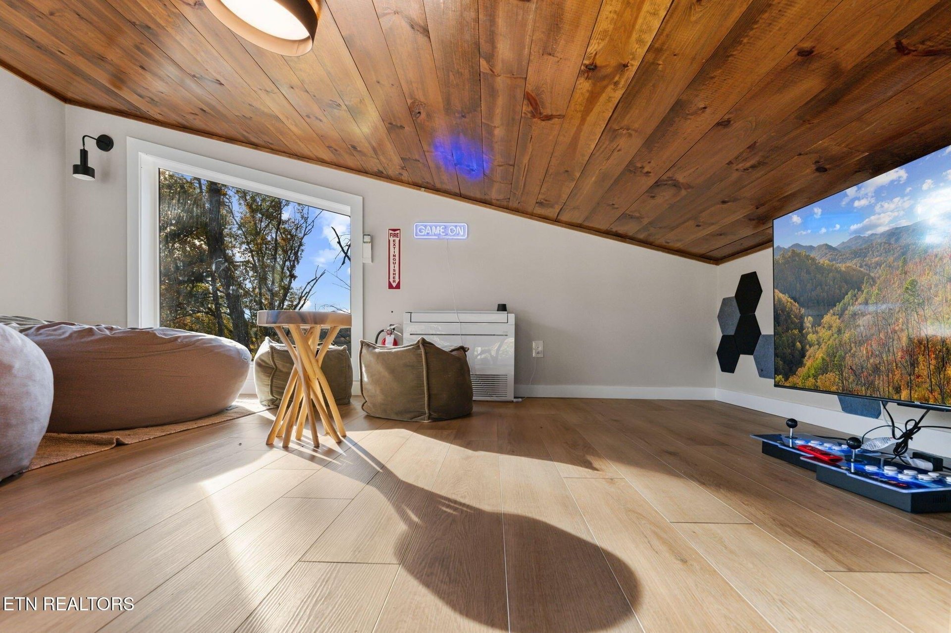 Your personal game loft awaits under stunning woodbeamed ceilings, with natural light streaming through real windows. Warm wood floors and cozy bean bags invite you to unwind between epic matches.
