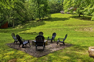 Picture yourself unwinding around this fire pit, surrounded by lush trees and open lawn—a perfect spot for evening conversations and making memories under the stars.