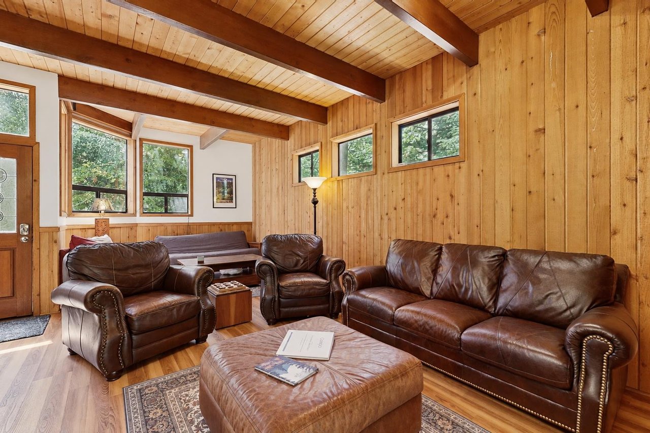 A second angle on the inviting leather seating arrangement, centered around a round ottoman — the perfect spot to put your feet up after a day exploring Strawberry Creek.