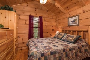 Kingsized log bed at Boogie Bear, a 1bedroom cabin rental located in Gatlinburg
