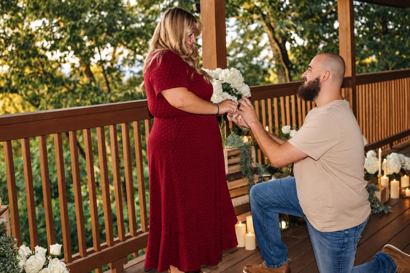 A romantic moment unfolds on a private deck surrounded by lush greenery, capturing a special milestone in a scenic, intimate setting.