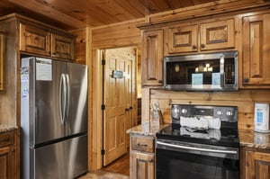Cook your favorite meals in this fully equipped kitchen featuring stainless steel appliances, granite countertops, and warm wood cabinetry. Modern conveniences meet rustic charm in this inviting space