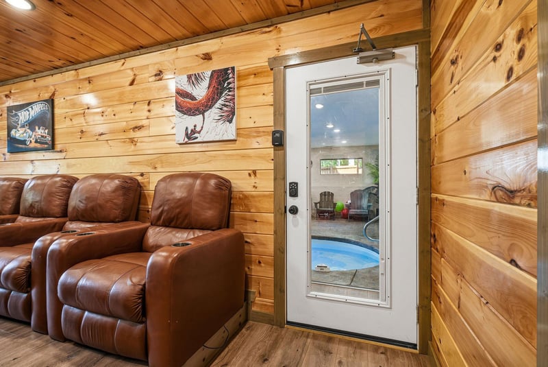 Sink into plush leather recliners in your cozy cabin retreat, where warm wood walls create the perfect atmosphere for relaxation.