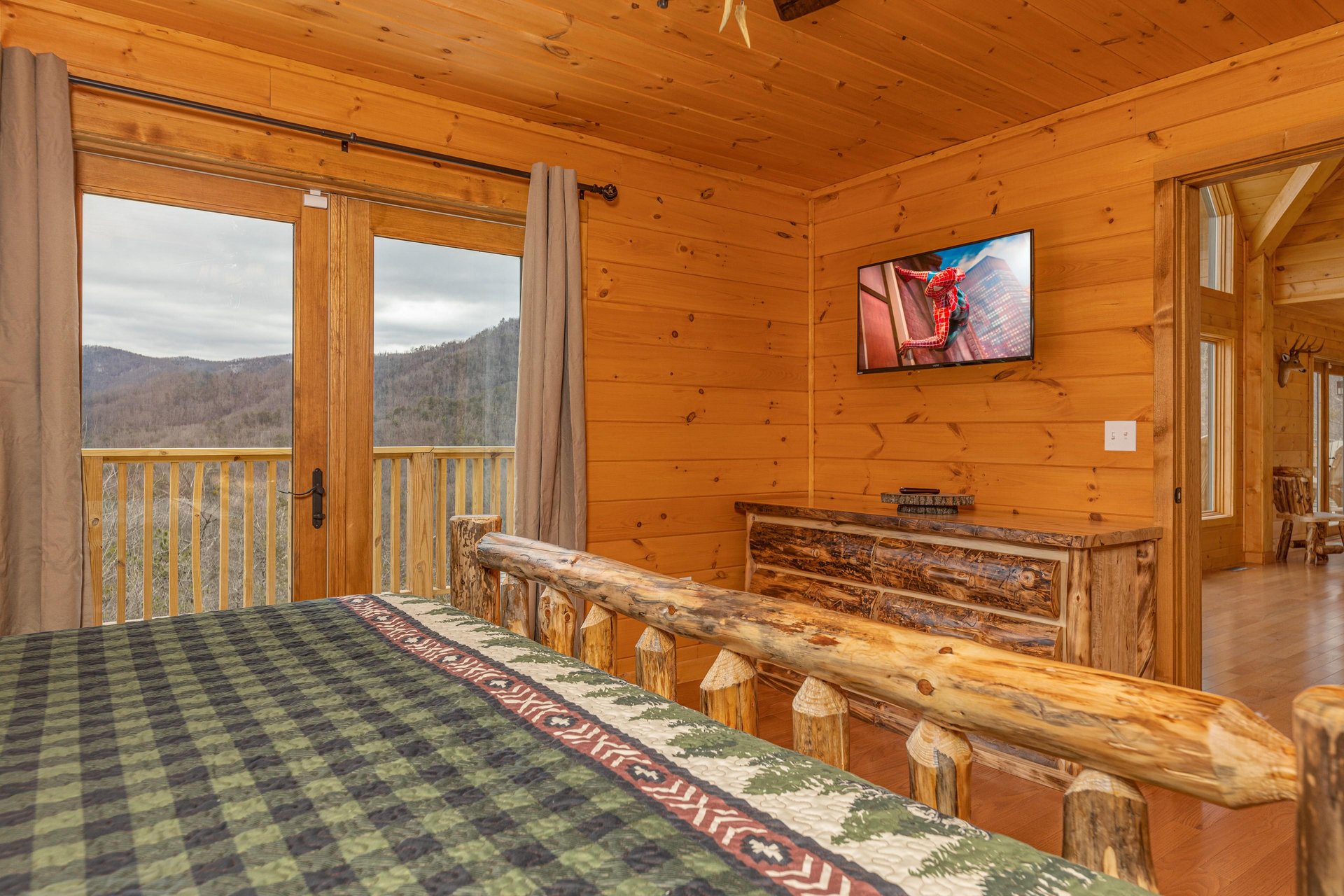 Dresser, TV, and deck access in a bedroom at Js Hideaway, a 4 bedroom cabin rental located in Pigeon Forge