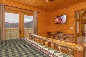 Dresser, TV, and deck access in a bedroom at Js Hideaway, a 4 bedroom cabin rental located in Pigeon Forge