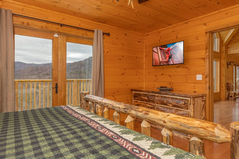 Dresser, TV, and deck access in a bedroom at Js Hideaway, a 4 bedroom cabin rental located in Pigeon Forge