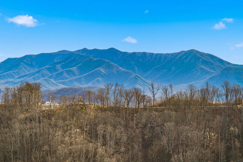 Majestic mountain ranges stretch across the horizon, creating a stunning backdrop for this scenic location with rolling hills and natural beauty.