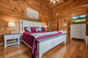 Drift off in this inviting bedroom with its soaring vaulted ceiling and warm knotty pine walls. Your plush bed is complemented by elegant farmhouse furnishings and gentle bedside lighting for a cozy m