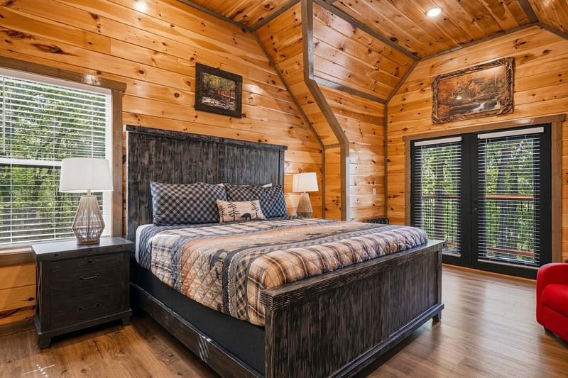 Retreat to your rustic bedroom where warm wood walls embrace a cozy plaiddressed bed, creating the perfect mountain cabin escape.