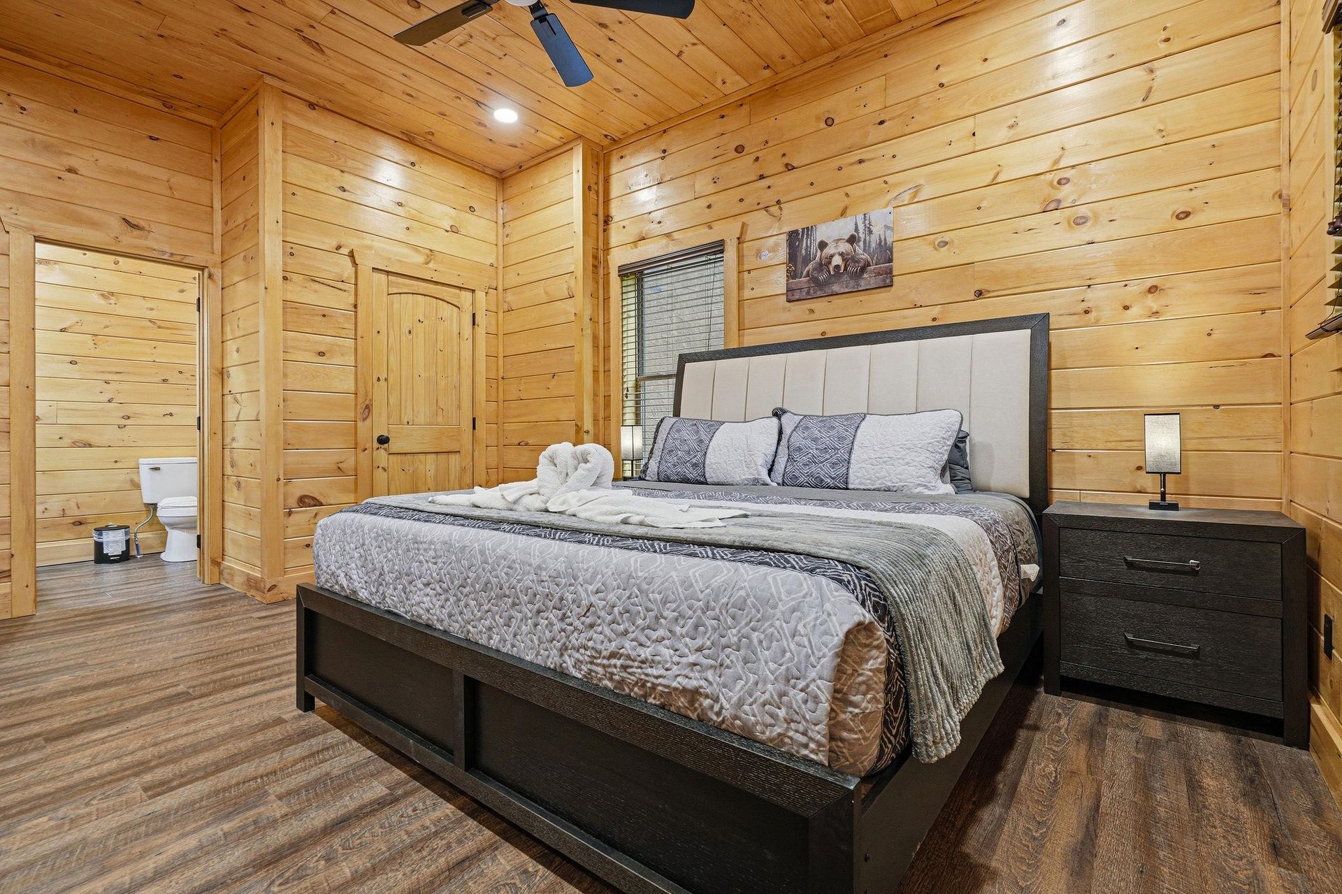 Drift off in your cozy cabin bedroom, surrounded by warm wood walls and mountaininspired decor that creates the perfect retreat.