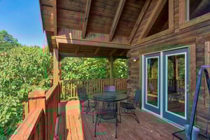 dining space for four on a covered deck at angels majestic view a 3 bedroom cabin rental located in pigeon forge