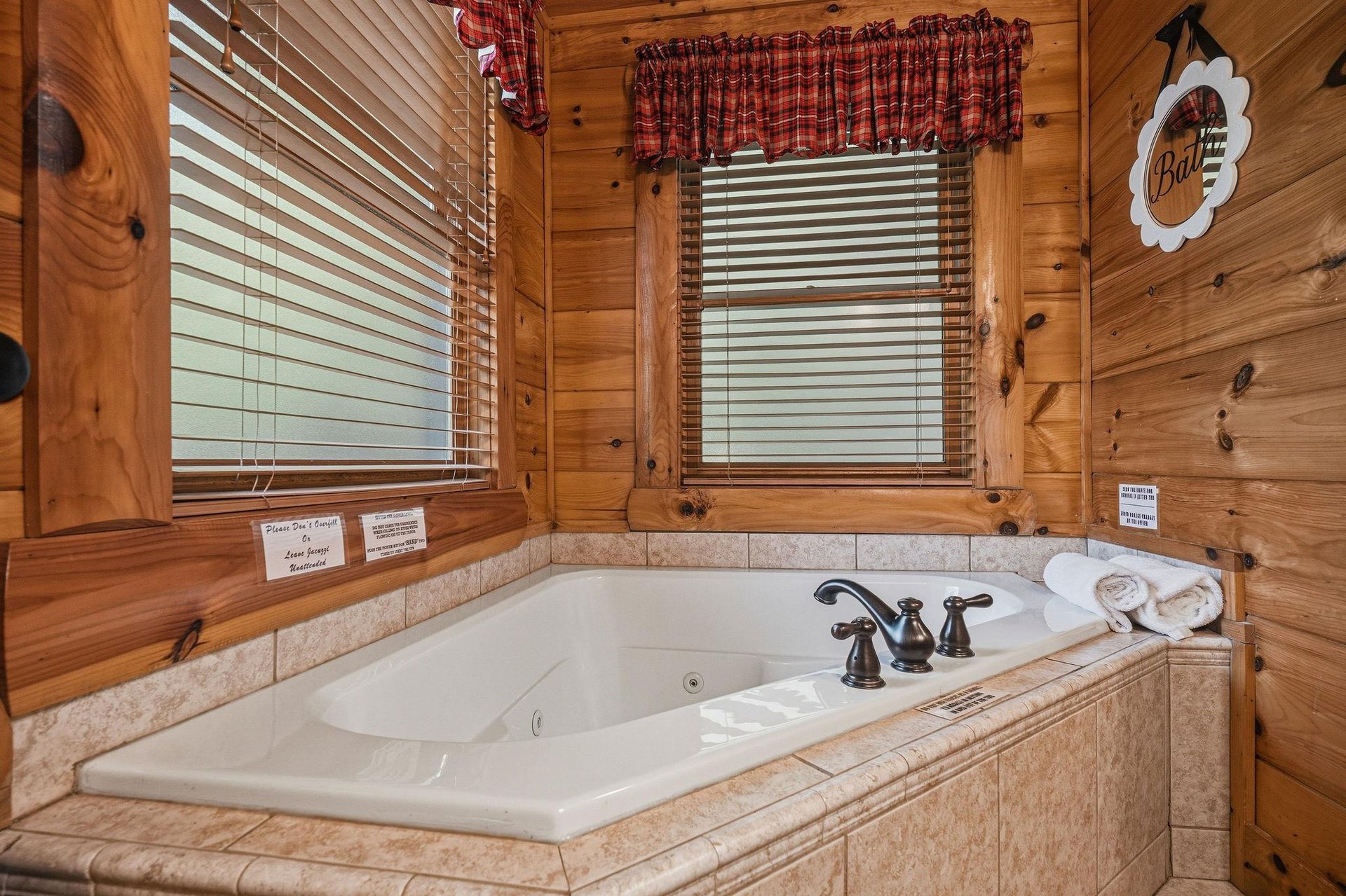 Sink into warmth in your private jetted tub, where rustic cabin charm meets pure relaxation. Sunlight filters through the blinds as fluffy towels await your soak.