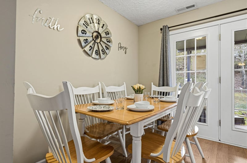 Gather around your charming dining table where morning coffee and evening meals become cherished memories beneath inspiring wall art.