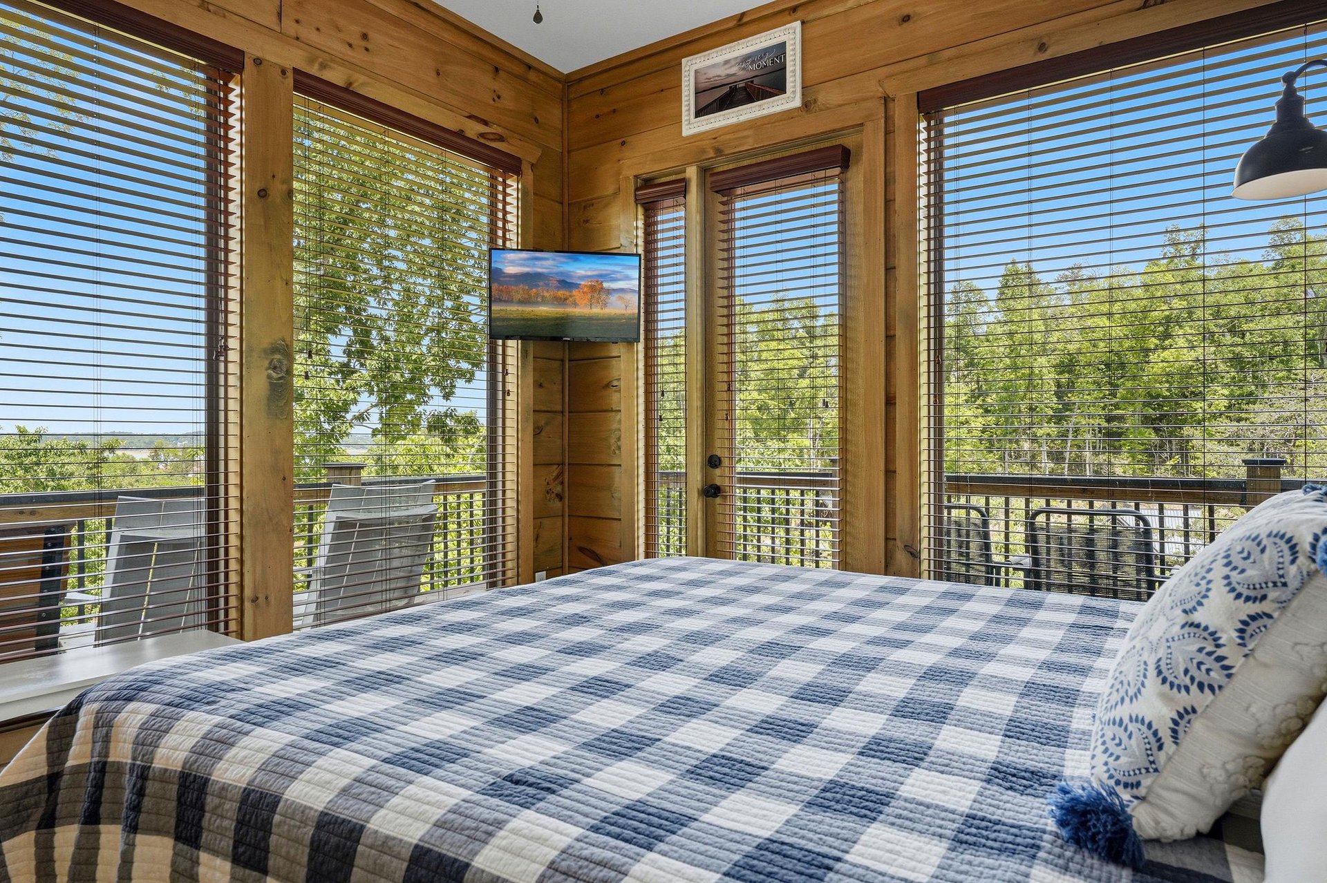 Wake up surrounded by floortoceiling windows in your cozy bedroom, where warm wood walls frame stunning treetop views that make every morning magical.