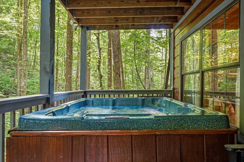 Soak in the hot tub under a covered deck, surrounded by lush forest views. The perfect spot to unwind after a day of adventure.