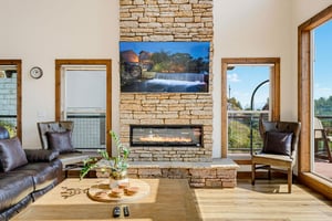 Gather around the stone fireplace and sink into inviting leather seating while natural light pours through expansive windows. The warm wood and rustic stone create a cozy retreat where your group can 