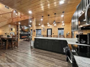 Step into your spacious mountain retreat where modern luxury meets rustic charm. Dark cabinets and marble countertops create the perfect cooking space.