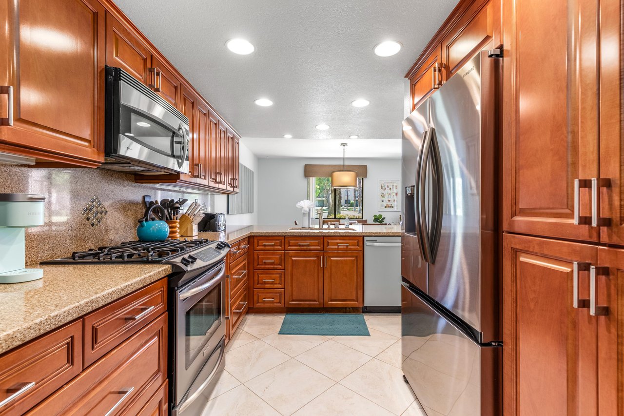Stainless steel appliances, cooking essentials, and easy flow into the dining space.