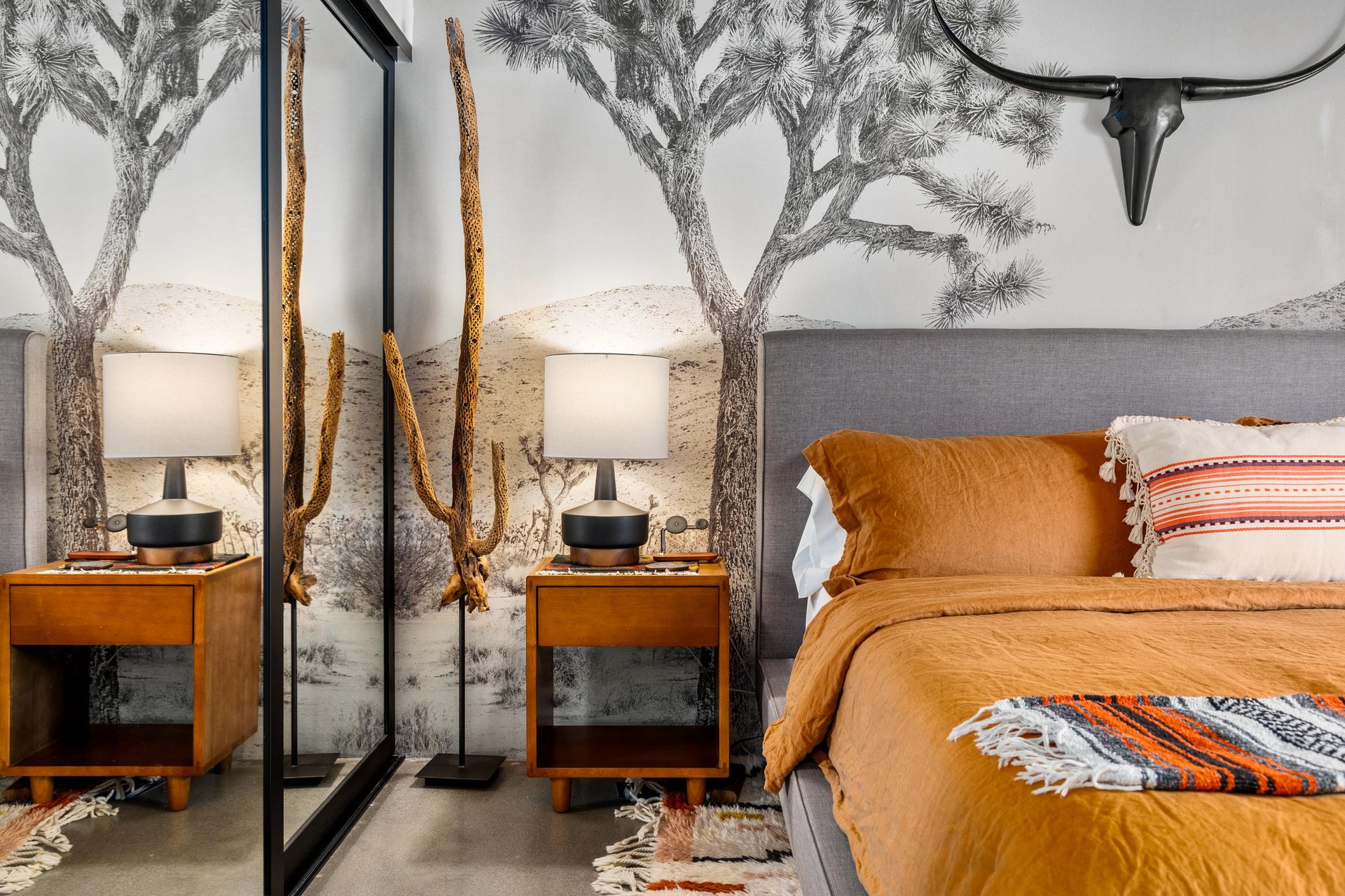 Drift off in your desertinspired sanctuary with warm terracotta linens and striking Joshua tree wallpaper creating a peaceful southwestern retreat.