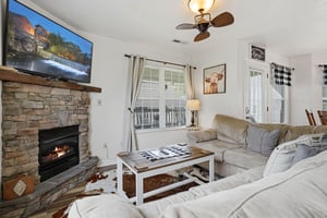 Sink into plush sofas by the stone fireplace, your favorite shows on the big screen, while the ceiling fan keeps you perfectly comfortable in this inviting living space.