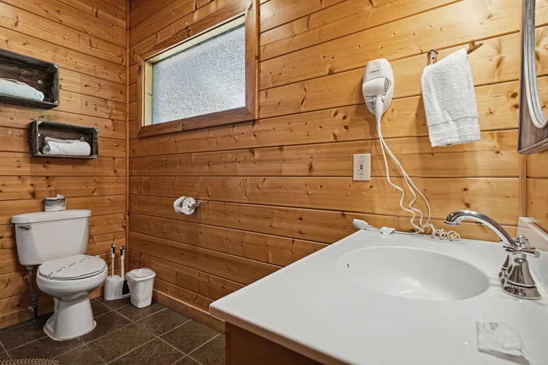 Rustic wood paneling and clean, modern fixtures create a cozy, cabinstyle bathroom thats simple yet comfortable. Fresh towels and a hair dryer are ready for your use.