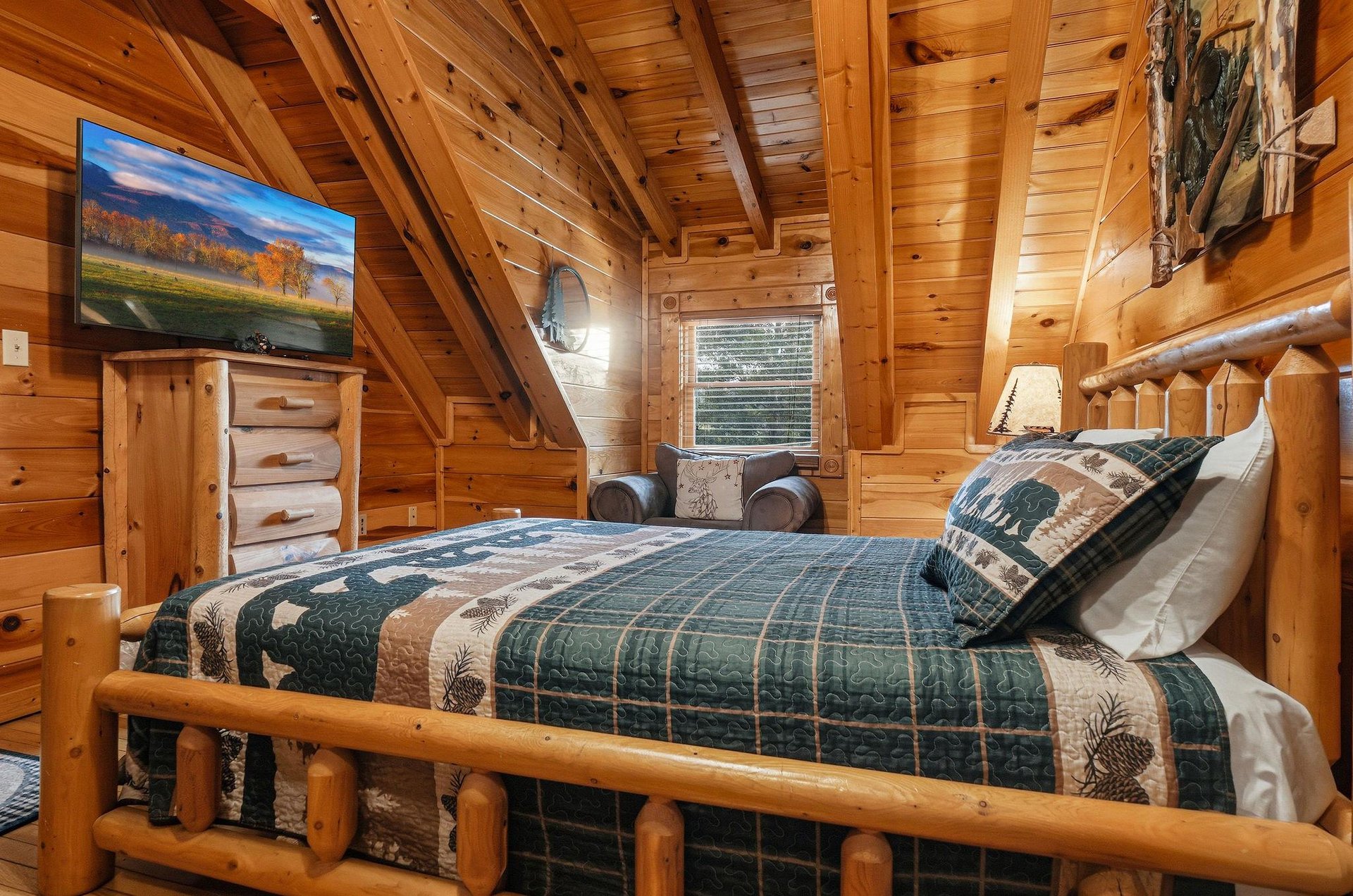 Drift off in your cozy cabin bedroom, where rustic log furniture and warm wood walls create the perfect mountain retreat for restful nights.