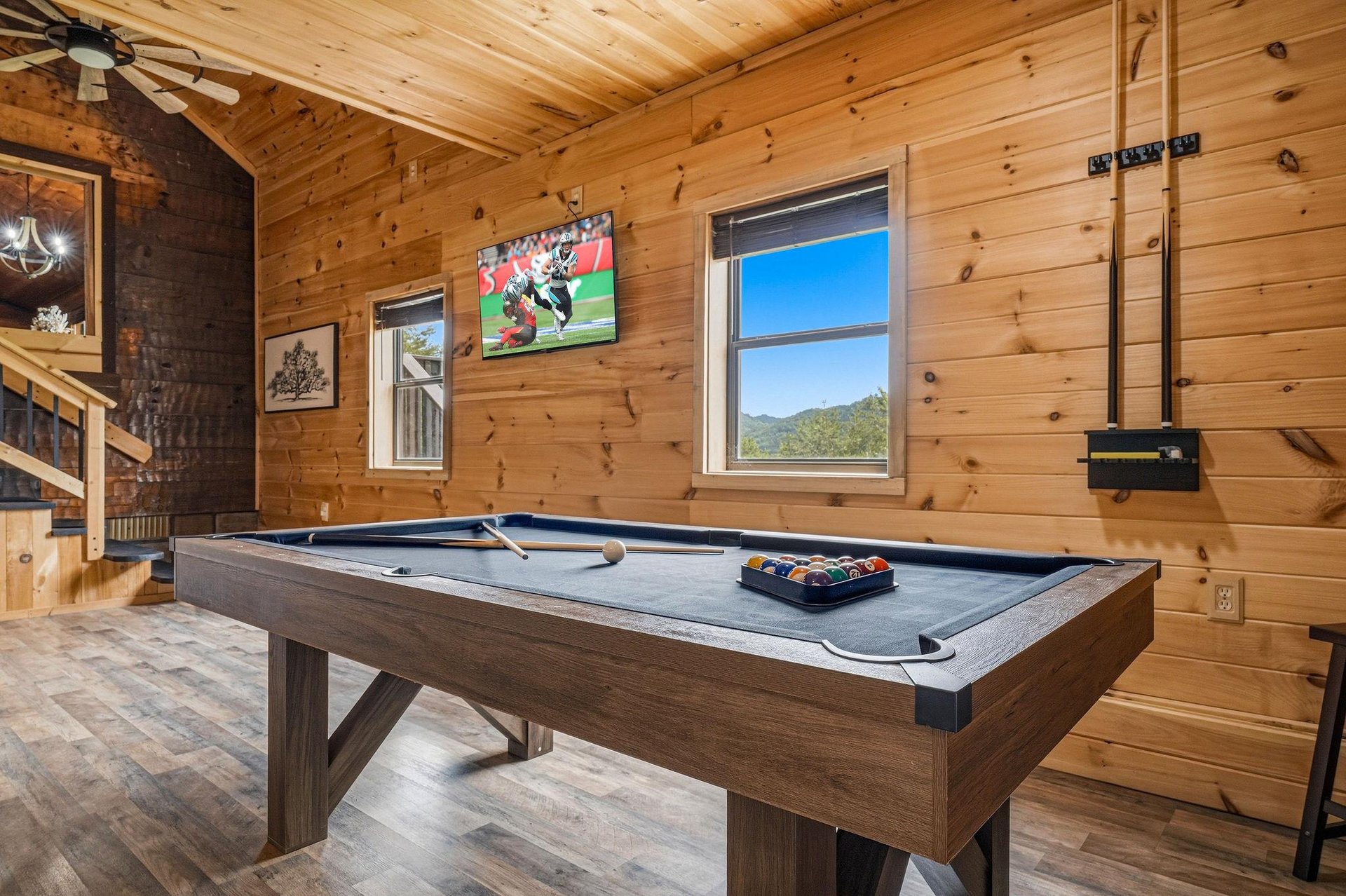 Challenge your friends to a game of pool in this rustic game room, where warm pine walls and mountain views create the perfect backdrop for relaxed competition.