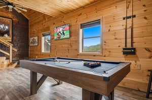 Challenge your friends to a game of pool in this rustic game room, where warm pine walls and mountain views create the perfect backdrop for relaxed competition.