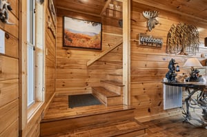 Step inside your cozy cabin retreat where rustic charm welcomes you with warm wood tones, charming décor, and inviting mountain views displayed throughout the space.