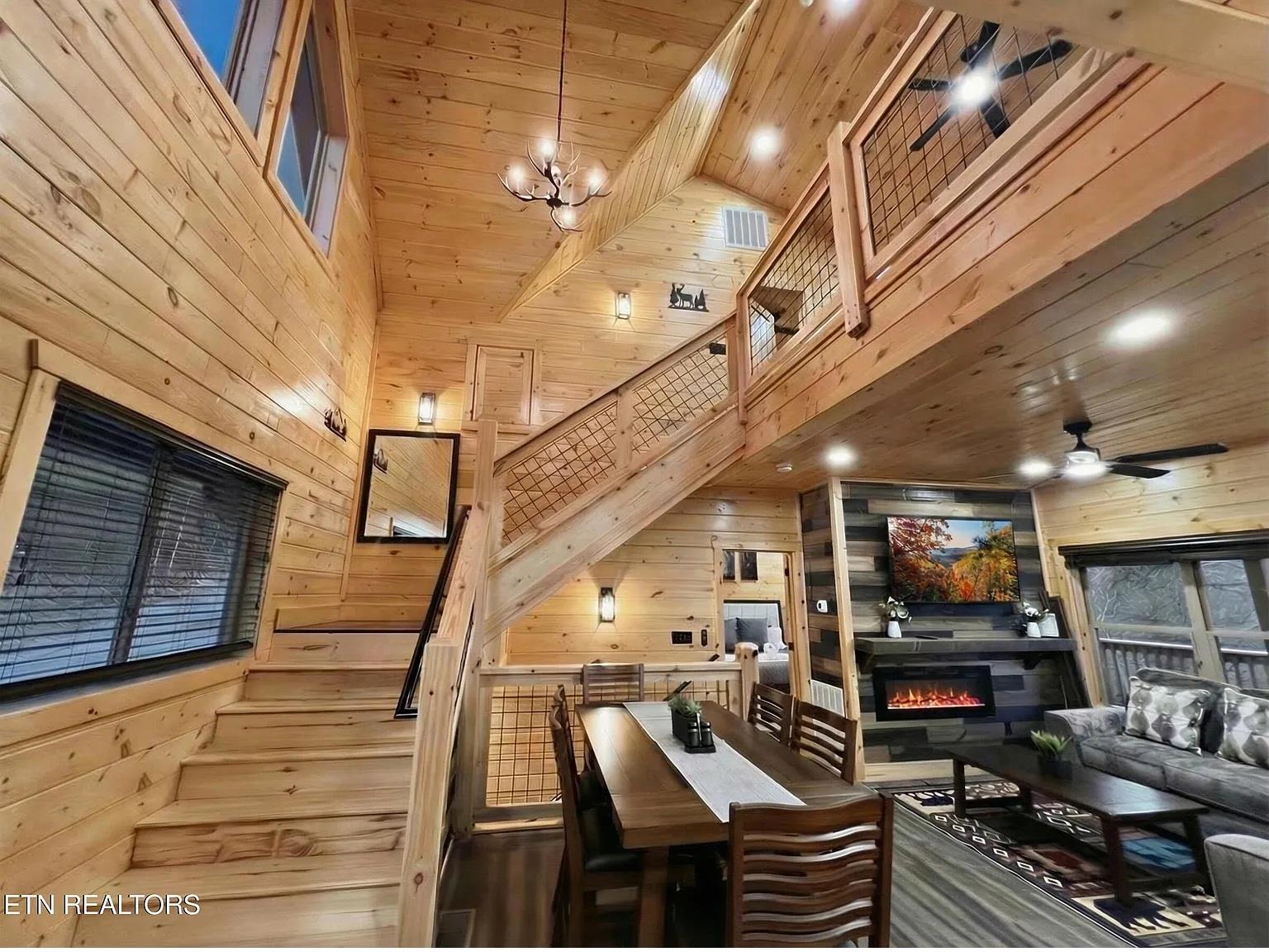 Relax in your stunning modern cabin featuring soaring wooden ceilings, a cozy fireplace, and an open loft design perfect for your mountain getaway.