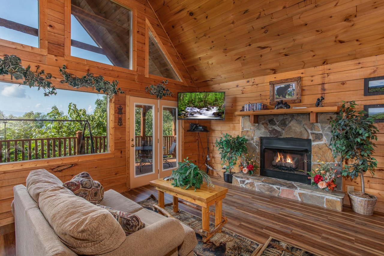 stone fireplace and wall mounted television at angels majestic view a 3 bedroom cabin rental located in pigeon forge