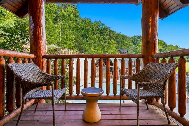 Picture yourself sipping morning coffee here, gazing at lush forested hills from your private covered balcony, where woven chairs and warm wood create an inviting mountain retreat.