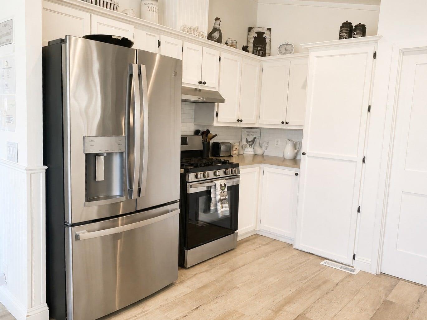 Warm woodpaneled ceilings complement stainless steel appliances, a wine fridge, and a coffee station.