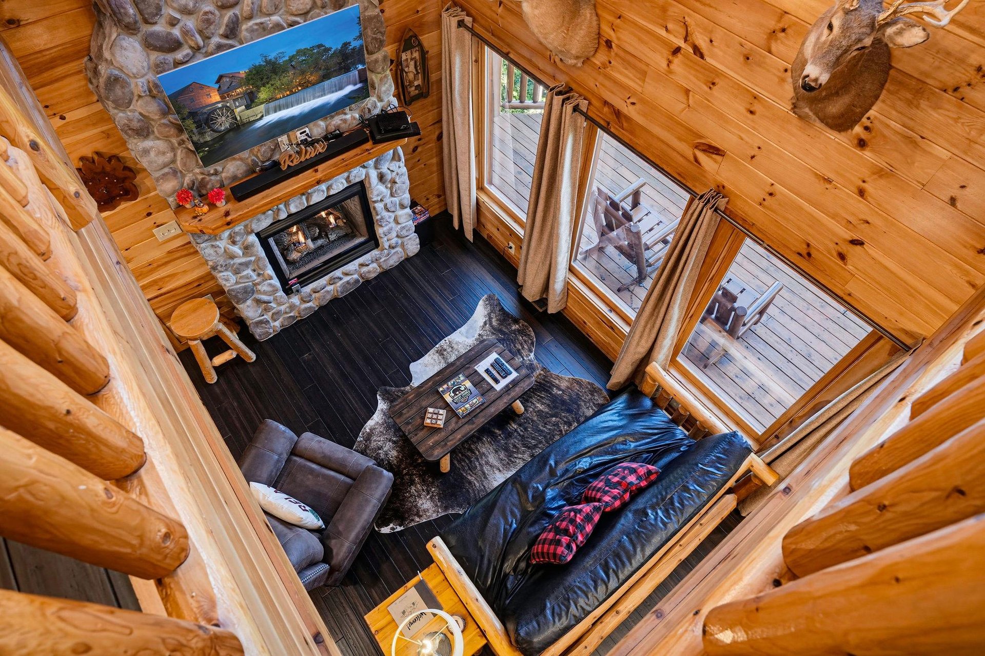 Soaring ceilings and rustic timber create a cozy retreat where you can unwind by the fireplace, sink into plush seating, and enjoy natural light streaming through tall windows.