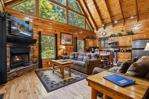 Relax in your openconcept living space with vaulted ceilings, warm wood finishes, and a cozy stone fireplace. Sunlight pours through floortoceiling windows, blending comfort with natures beauty.