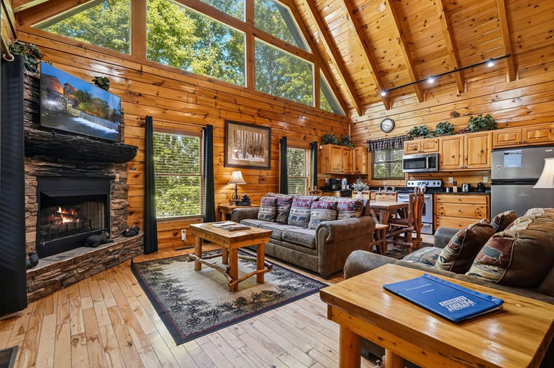 Relax in your openconcept living space with vaulted ceilings, warm wood finishes, and a cozy stone fireplace. Sunlight pours through floortoceiling windows, blending comfort with natures beauty.