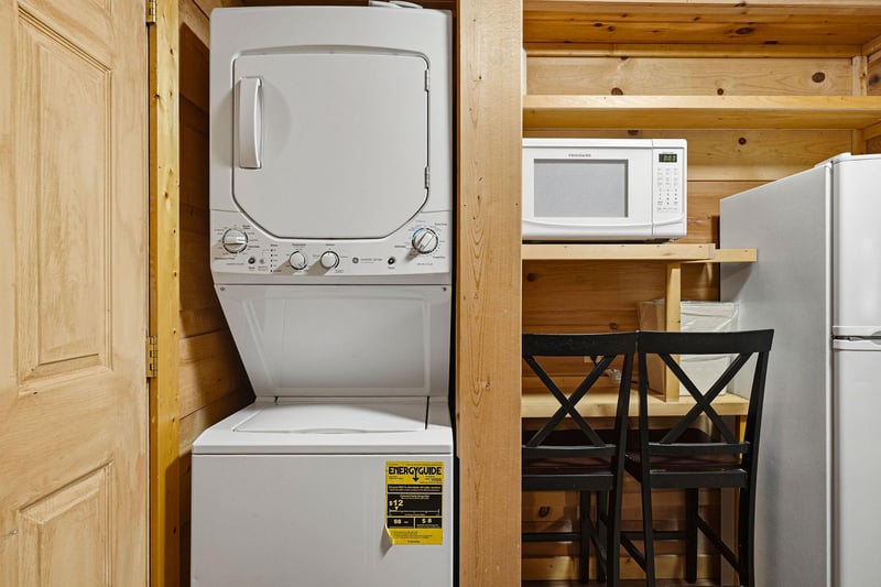 This space includes a stacked washer and dryer, microwave, and fridge—everything you need for a comfortable, selfsufficient stay in your home away from home.