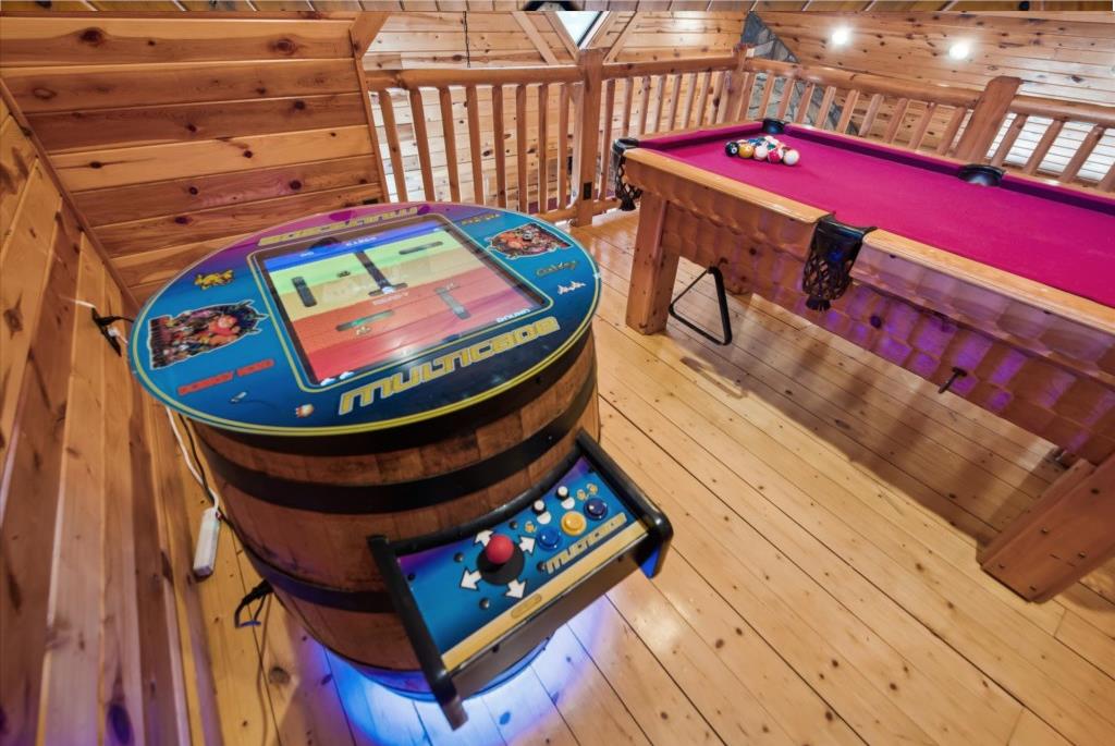 Your personal game room awaits with vintage arcade action and pool table fun in this cozy wooden loft space.