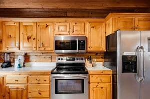 Your fully equipped kitchen features warm knotty pine cabinetry, modern stainless appliances, and everything you need to prepare meals during your mountain getaway.